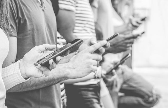 People focusing on mobile phones, representing audience targeting and reach